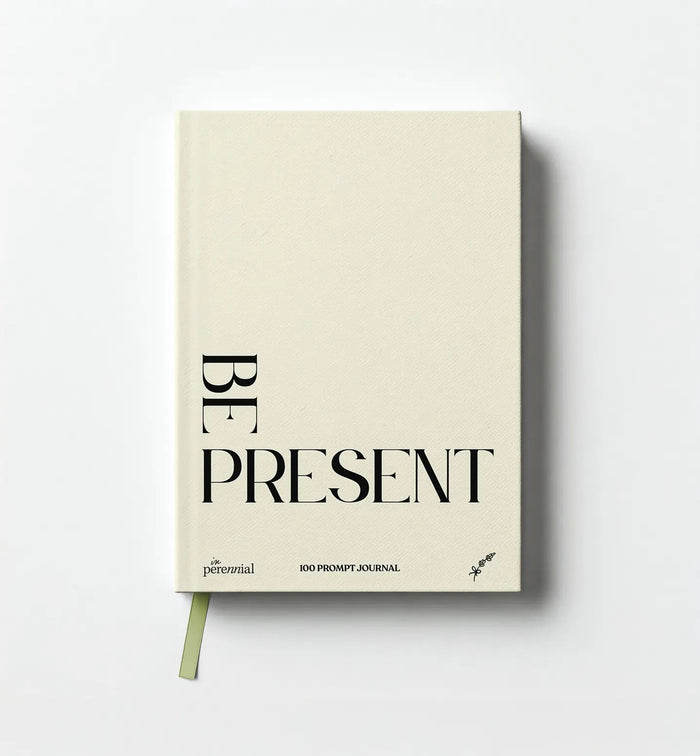Front cover of in Perennial's beige Be Present 100 Prompt Journal, with black lettering and a green ribbon bookmark.
